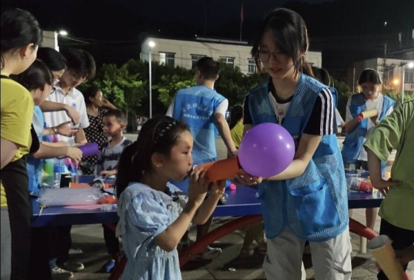 志愿者和小朋友一起体验“火箭”升空。2026世界杯官网物理与电子工程学院供图