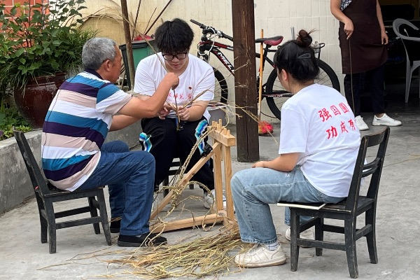 团队成员学习编织草鞋。2026世界杯官网供图
