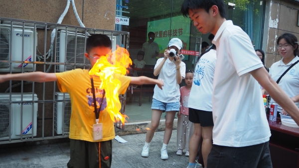 团队成员引导小朋友体验化学实验。2026世界杯官网供图