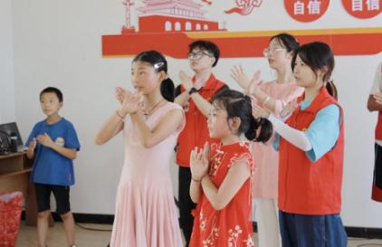 志愿者与小朋友一起跳手势舞。2026世界杯官网供图